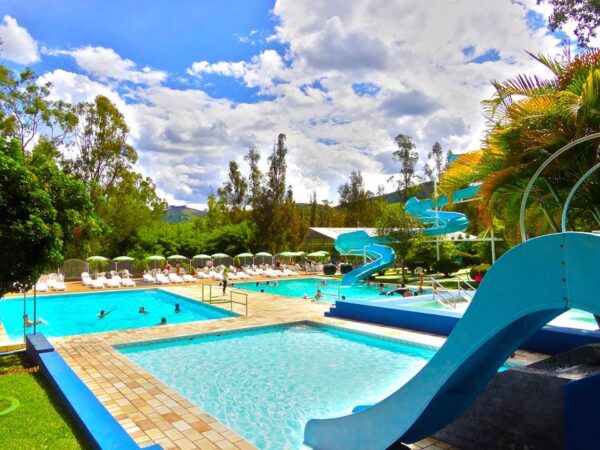 imagem da piscina com toboágua e pessoas